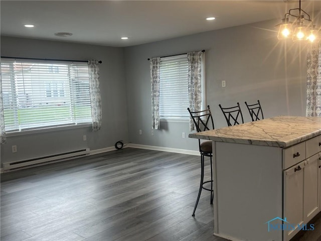 118 N Main St, Bloomdale, OH 44817 - kitchen with baseboard heating, healthy amount of natural light, a breakfast bar area, dark wood-style floors, and recessed lighting