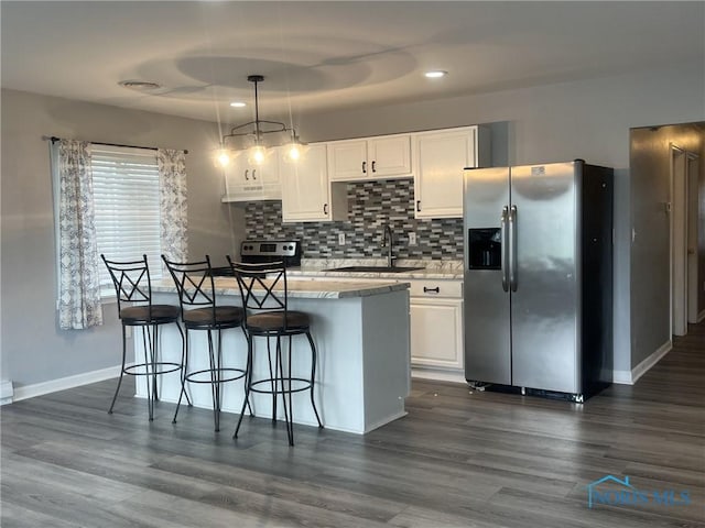 118 N Main St, Bloomdale, OH 44817 - kitchen featuring stainless steel appliances, a sink, white cabinets, a breakfast bar, and under cabinet range hood