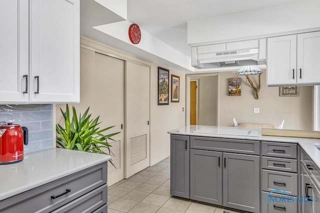 4426 Sheraton Rd, Ottawa Hills, OH 43615 - kitchen with gray cabinets, light countertops, cooktop, decorative backsplash, and under cabinet range hood