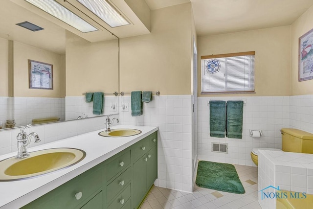 4426 Sheraton Rd, Ottawa Hills, OH 43615 - full bath featuring tile patterned flooring, tile walls, double vanity, toilet, and wainscoting