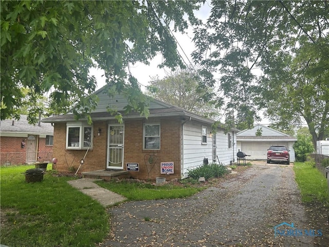1217 Freedom St, Toledo, OH 43605 - view of front facade featuring brick siding, fence, a detached garage, and an outdoor structure