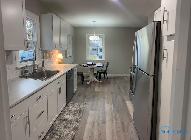 613 W Yeasting St, Gibsonburg, OH 43431 - kitchen featuring freestanding refrigerator, a sink, dishwasher, tasteful backsplash, and light wood-type flooring