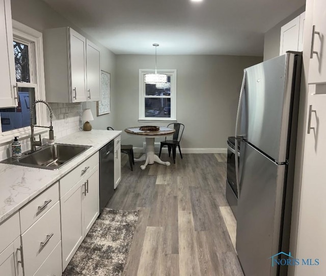 613 W Yeasting St, Gibsonburg, OH 43431 - kitchen with freestanding refrigerator, a sink, baseboards, dishwasher, and white cabinets