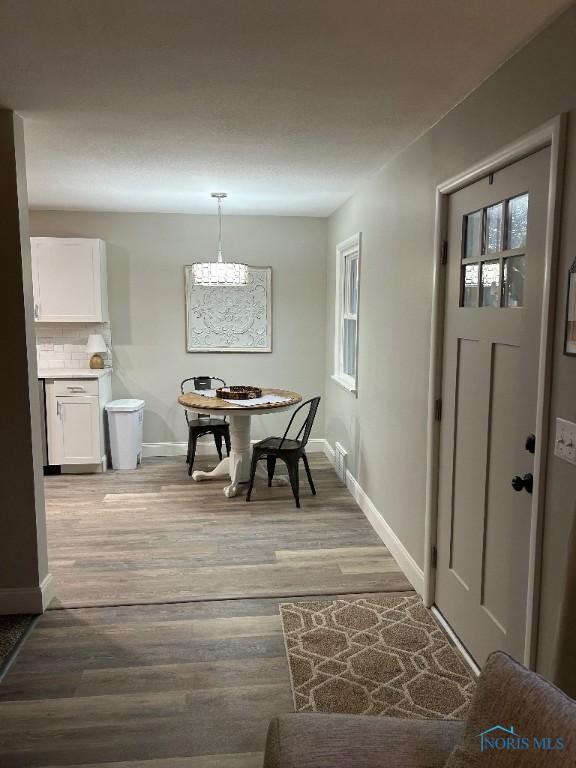 613 W Yeasting St, Gibsonburg, OH 43431 - dining room with baseboards, plenty of natural light, light wood-style flooring, and a chandelier
