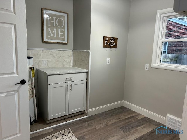 613 W Yeasting St, Gibsonburg, OH 43431 - laundry room featuring dark wood-style floors, water heater, and baseboards