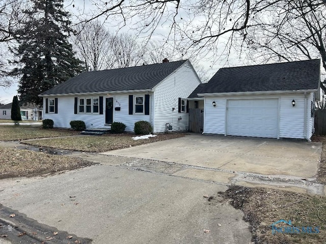 613 W Yeasting St, Gibsonburg, OH 43431 - view of front facade with concrete driveway, a chimney, and a garage