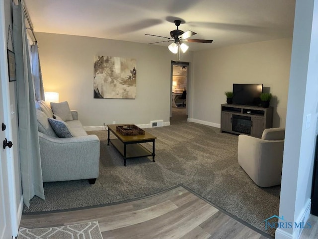 613 W Yeasting St, Gibsonburg, OH 43431 - living area featuring ceiling fan, baseboards, a fireplace, and wood finished floors