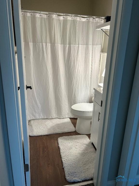 613 W Yeasting St, Gibsonburg, OH 43431 - full bathroom with vanity, toilet, curtained shower, and wood finished floors