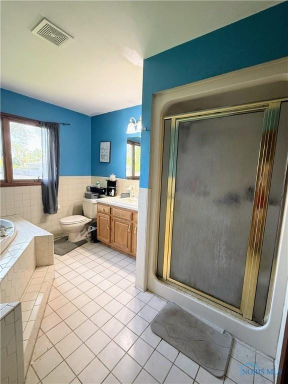 801 W Sandusky St, Findlay, OH 45840 - bathroom featuring tile patterned floors, plenty of natural light, tile walls, a shower stall, and vanity