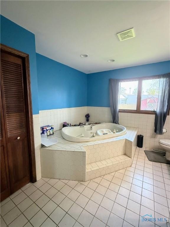 801 W Sandusky St, Findlay, OH 45840 - full bathroom with tile patterned floors, a garden tub, toilet, and a wainscoted wall