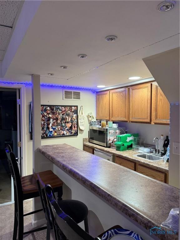 801 W Sandusky St, Findlay, OH 45840 - kitchen with appliances with stainless steel finishes, a breakfast bar, a sink, recessed lighting, and brown cabinetry