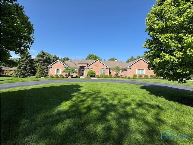 ranch-style house featuring a front yard and brick siding