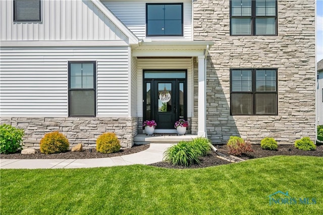 5653 Mallard Pointe Ln, Sylvania, OH 43560 - doorway to property with stone siding, board and batten siding, and a yard