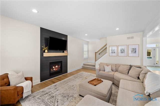 5653 Mallard Pointe Ln, Sylvania, OH 43560 - living room featuring wood finished floors, a large fireplace, stairway, recessed lighting, and baseboards