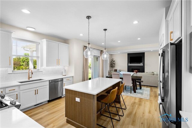 5653 Mallard Pointe Ln, Sylvania, OH 43560 - kitchen with stainless steel appliances, a sink, open floor plan, white cabinetry, and recessed lighting