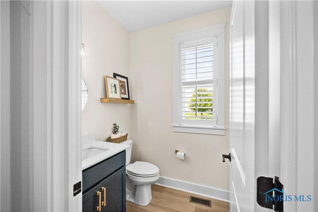 5653 Mallard Pointe Ln, Sylvania, OH 43560 - bathroom with baseboards, wood finished floors, toilet, and vanity