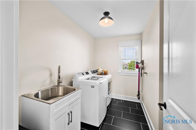 5653 Mallard Pointe Ln, Sylvania, OH 43560 - washroom with washing machine and dryer, baseboards, cabinet space, and dark tile patterned flooring