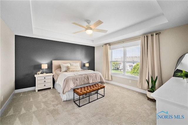 5653 Mallard Pointe Ln, Sylvania, OH 43560 - bedroom with a tray ceiling, light colored carpet, baseboards, and ceiling fan