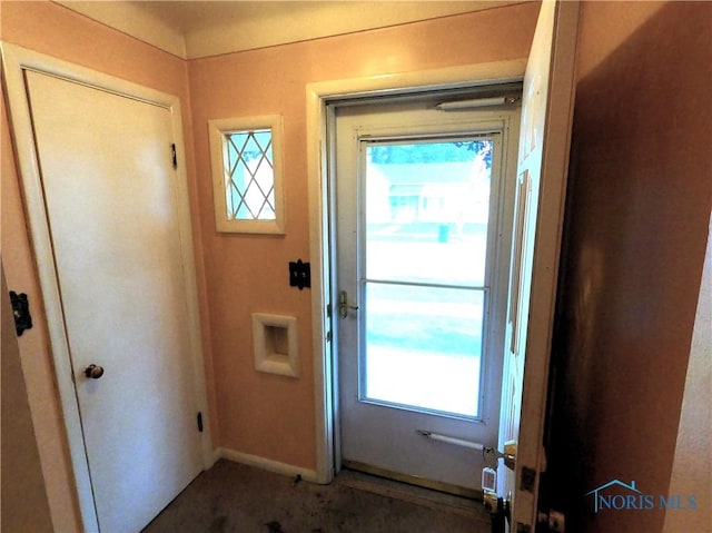 651 Park St, Napoleon, OH 43545 - doorway to outside featuring baseboards and carpet
