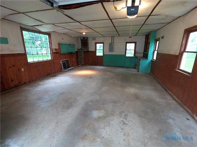 651 Park St, Napoleon, OH 43545 - garage featuring electric panel, wood walls, wainscoting, and a garage door opener