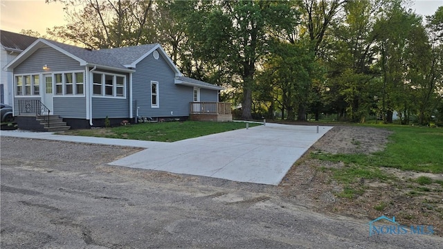 103 E N St, Liberty Center, OH 43532 - view of side of home featuring a lawn, driveway, and roof with shingles