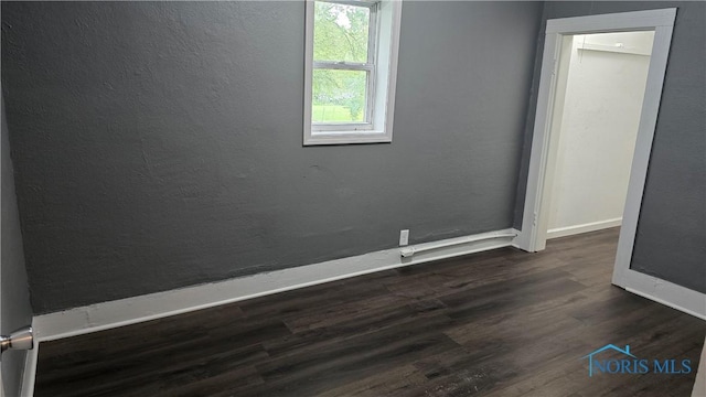103 E N St, Liberty Center, OH 43532 - empty room featuring baseboards and dark wood-type flooring