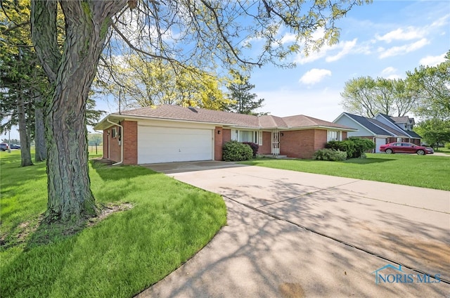 403 S N Curtice Rd, Oregon, OH 43616 - ranch-style house with concrete driveway, a garage, brick siding, and a front lawn