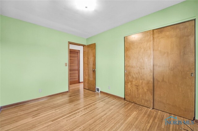 403 S N Curtice Rd, Oregon, OH 43616 - unfurnished bedroom featuring wood finished floors, a closet, and baseboards