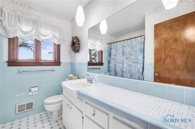 403 S N Curtice Rd, Oregon, OH 43616 - full bathroom with wallpapered walls, a wainscoted wall, toilet, tile walls, and a shower with shower curtain