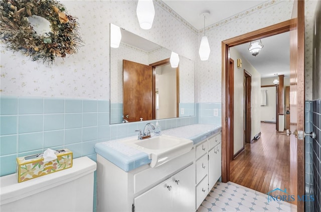 403 S N Curtice Rd, Oregon, OH 43616 - bathroom featuring wallpapered walls, a wainscoted wall, toilet, vanity, and wood finished floors