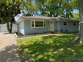 view of front facade with a garage, a front yard, and driveway