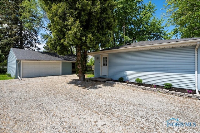 view of front of property featuring an outdoor structure and a detached garage