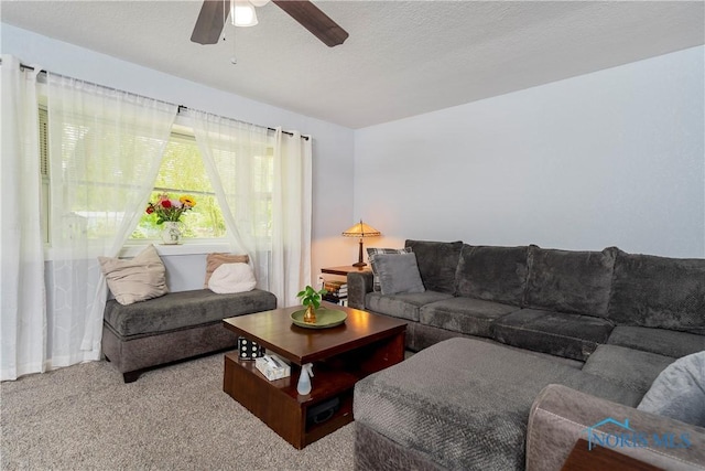 living area featuring a ceiling fan and carpet
