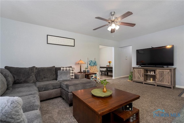 living room featuring ceiling fan, carpet, and baseboards
