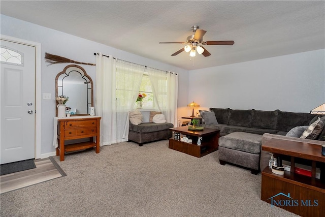 carpeted living area featuring a ceiling fan