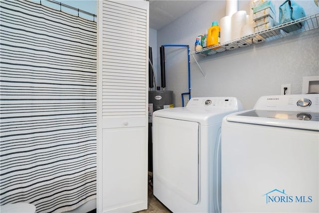 washroom featuring washing machine and dryer and a textured wall