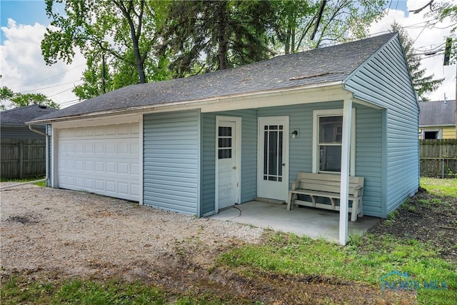 detached garage featuring fence