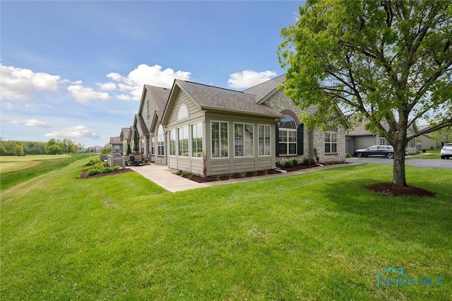 2730 Canterbury Cir Unit 23B, Port Clinton, OH 43452 - view of side of home featuring a lawn, a patio area, and roof with shingles