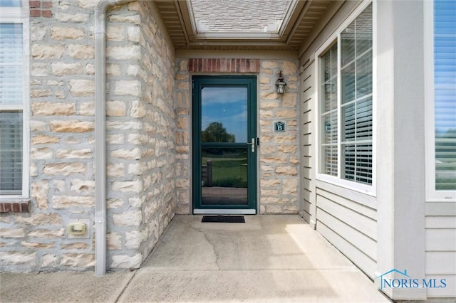 2730 Canterbury Cir Unit 23B, Port Clinton, OH 43452 - doorway to property featuring stone siding and roof with shingles