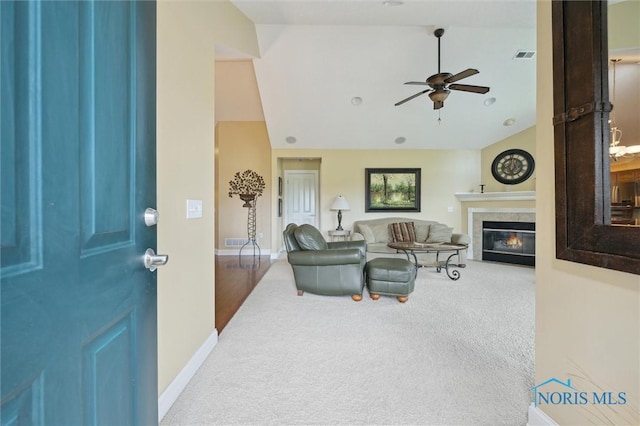 2730 Canterbury Cir Unit 23B, Port Clinton, OH 43452 - living room featuring carpet flooring, ceiling fan, vaulted ceiling, baseboards, and a tiled fireplace