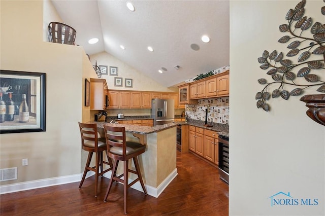 2730 Canterbury Cir Unit 23B, Port Clinton, OH 43452 - kitchen featuring a peninsula, a kitchen breakfast bar, dark stone countertops, decorative backsplash, and glass insert cabinets