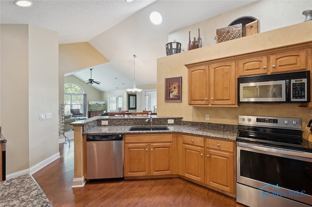 2730 Canterbury Cir Unit 23B, Port Clinton, OH 43452 - kitchen featuring appliances with stainless steel finishes, a sink, dark wood-style flooring, a peninsula, and lofted ceiling