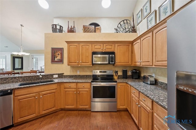 2730 Canterbury Cir Unit 23B, Port Clinton, OH 43452 - kitchen with stainless steel appliances, a sink, dark stone countertops, pendant lighting, and dark wood-type flooring
