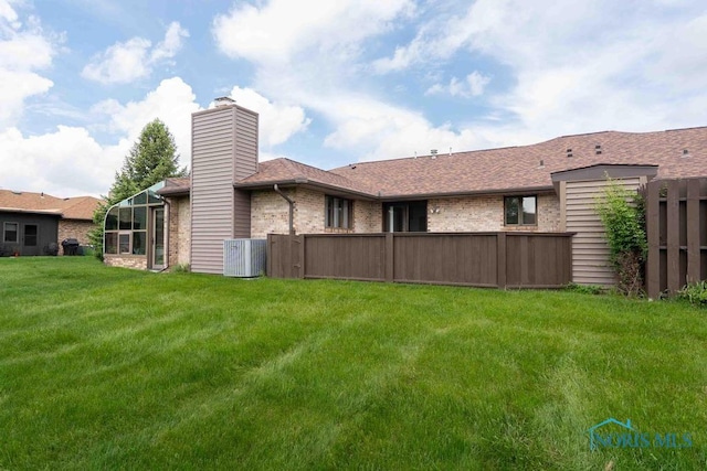 2023 Bluestone Dr, Findlay, OH 45840 - rear view of property featuring cooling unit, brick siding, a chimney, and a shingled roof
