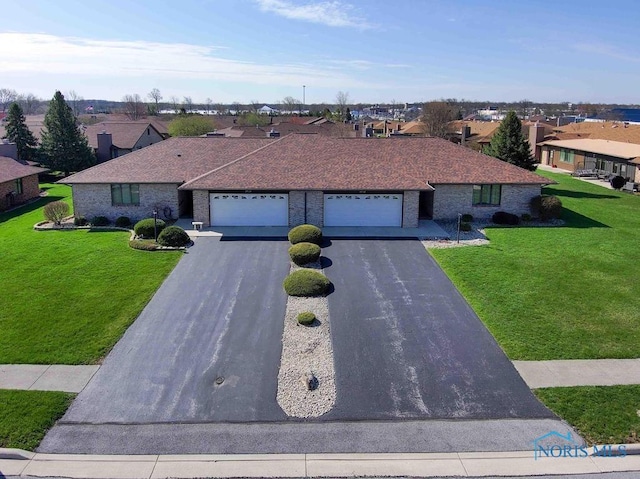 2023 Bluestone Dr, Findlay, OH 45840 - ranch-style house with a residential view, asphalt driveway, a front yard, an attached garage, and brick siding