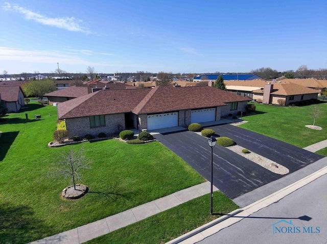 2023 Bluestone Dr, Findlay, OH 45840 - ranch-style house with a garage, a residential view, asphalt driveway, a front yard, and brick siding