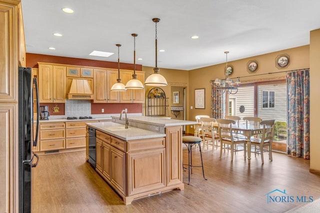 14360 County Road 2, Swanton, OH 43558 - kitchen featuring black appliances, premium range hood, light countertops, light wood-style floors, and backsplash