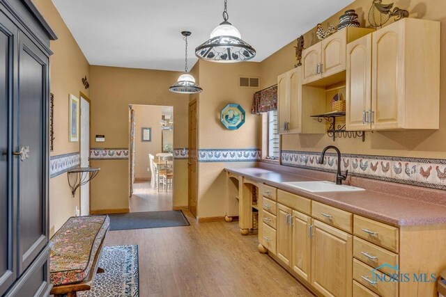 14360 County Road 2, Swanton, OH 43558 - kitchen with a sink, light brown cabinetry, light wood-style flooring, and decorative light fixtures