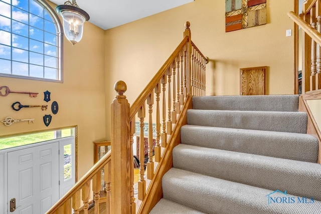14360 County Road 2, Swanton, OH 43558 - stairs with a chandelier, plenty of natural light, and a high ceiling