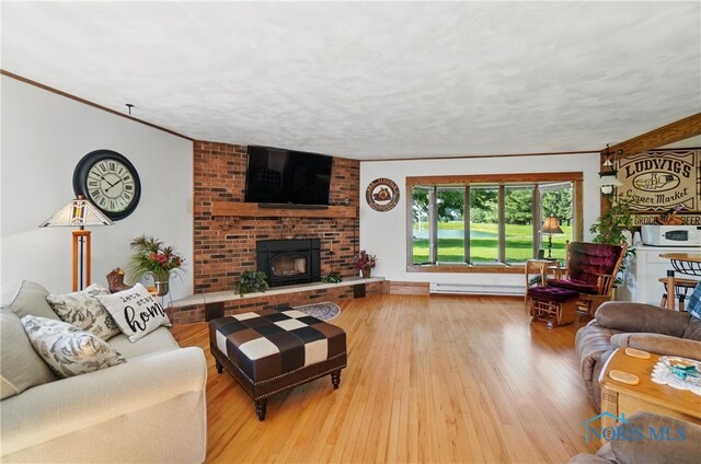 1482 Township Road 55, Ada, OH 45810 - living room with baseboard heating, wood-type flooring, a fireplace, and crown molding